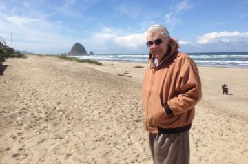 Photo of Doug, standing on a beach near Haystack Rock, Cannon Beach, Oregon.